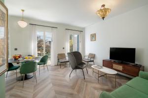 een woonkamer met een bank en een tafel en stoelen bij Madeira Gems Apartments in Funchal