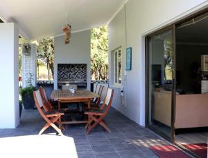 a patio with a wooden table and chairs at Vaal River House @ Lochvaal in Vanderbijlpark
