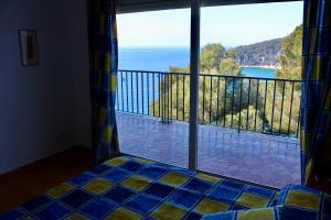 a room with a view of the ocean from a balcony at Apartamentos Cala Llevado in Tossa de Mar