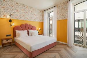 a bedroom with a large bed with yellow walls at Madeira Gems Apartments in Funchal