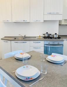 uma cozinha com uma mesa com pratos em Margherita 8 Apartments em Rimini