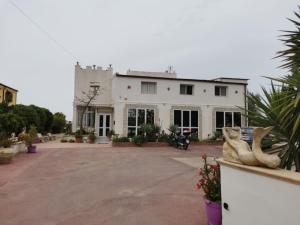 a large white house with a large driveway at Il Mirto E La Rosa in Arenella