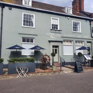 un edificio azul con mesas y sombrillas delante en The Quay en Faversham