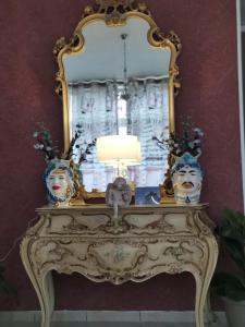 a mirror on top of a table with a lamp at Il Mirto E La Rosa in Arenella