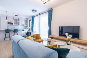a living room with a blue couch and a tv at Ledeno more Luxury Apartments in Split
