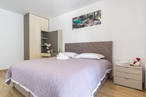 a bedroom with a large white bed and a phone at Ledeno more Luxury Apartments in Split