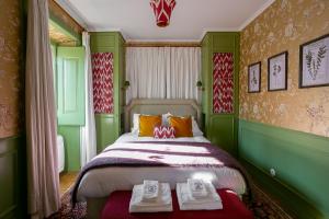 a green bedroom with a bed with two towels on it at Rosegarden Essence Sintra AL - by Unlock Hotels in Sintra