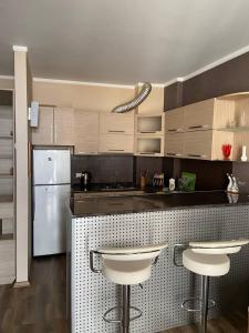 Orbi Plaza Apartment في باتومي: مطبخ مع كونتر وشرفتين من البار