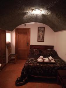 a bedroom with a bed with two pillows on it at Cueva El Murallon in Benamaurel