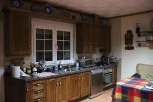 a kitchen with wooden cabinets and a sink and a microwave at Cueva El Murallon in Benamaurel