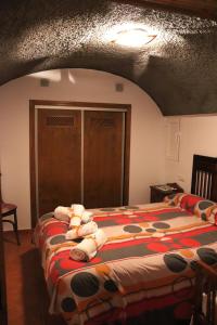 een slaapkamer met een bed met knuffels erop bij Cueva El Murallon in Benamaurel