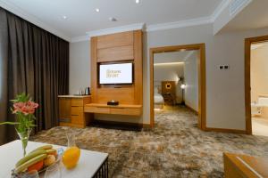 a living room with a television in a hotel room at Frankfort Hotel and Spa in Tashkent