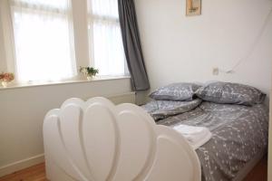 a white chair in a bedroom with a bed at hotel 't Doktershus in Lemmer