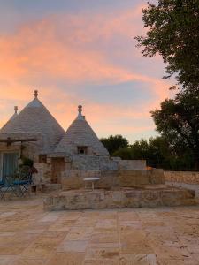 a stone building with two towers with a bench in front at Trulli da Lalli in Ostuni