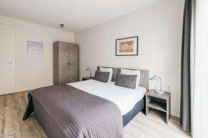 ein Schlafzimmer mit einem großen weißen Bett und einem Nachttisch in der Unterkunft Amsterdam Prince Island by YAYS in Amsterdam