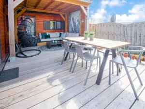 een houten terras met een houten tafel en stoelen bij Ibiza style chalet in Brouwershaven with lounge terrace in Brouwershaven