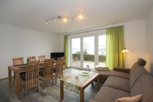 ein Wohnzimmer mit einem Sofa, einem Tisch und Stühlen in der Unterkunft F-1037 Ferienhaus Neuendorf Haus Terrasse, Gartennutzung, Meerblick in Lauterbach