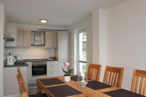 una cocina con una mesa de madera con sillas y una ventana en F-1037 Ferienhaus Neuendorf Haus Terrasse, Gartennutzung, Meerblick en Lauterbach