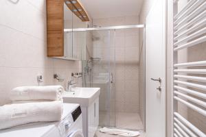 a white bathroom with a shower and a sink at Ledeno more Luxury Apartments in Split +71 photos