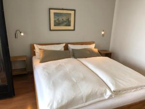 1 cama blanca grande en un dormitorio con una foto en la pared en Paolos Seehotel Mardorf, en Mardorf