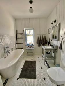 une salle de bain avec une grande baignoire et un lavabo dans l'établissement Spokój mi daj, à Sorkwity