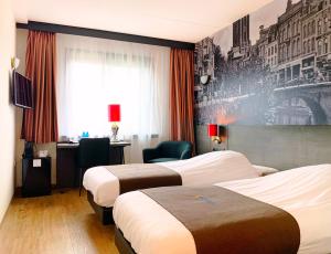 Cette chambre comprend deux lits et un bureau. dans l'établissement Bastion Hotel Utrecht, à Utrecht