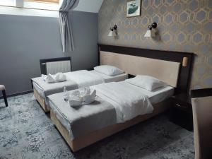 two twin beds in a hotel room with at Hotel Jedlinka in Jedlina-Zdrój