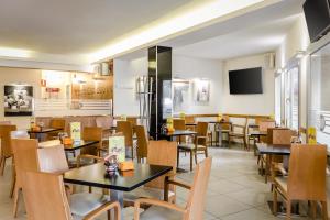 un restaurant avec des tables et des chaises et une télévision dans l'établissement Hotel Palacios, à Alfaro