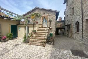 a stone house with a staircase in front of it at La casina del vicolo in Collelungo