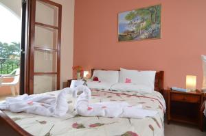 een slaapkamer met 2 bedden en zwanenhanddoeken bij Margarita Aparthotel in Ýpsos