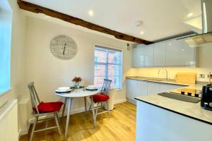 a kitchen with a table and chairs and a counter top at Tilly's a perfect apartment in the Market Town of Ledbury in Ledbury
