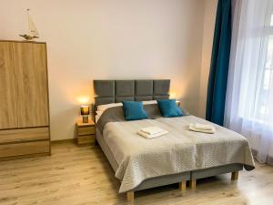 sypialnia z dużym łóżkiem z niebieskimi poduszkami w obiekcie Bałtycka Osada w mieście Jarosławiec