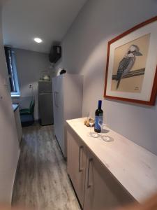 una cocina con nevera y una barra con una botella de vino en Götzer Apartman, en Komló