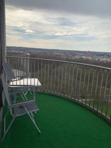 einen Balkon mit einem Stuhl und Stadtblick in der Unterkunft Sky Apartment im Hotelturm in Augsburg
