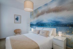 a bedroom with a bed with a painting on the wall at Villa Ada Malinska in Malinska