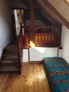 a bedroom with a bed in a room with wooden floors at Conacul lui Radu in Făgăraş