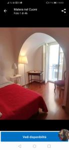 Habitación de hotel con cama roja y mesa con piscina en Matera nel Cuore, en Matera