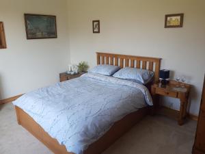 una camera da letto con un letto con un piumone blu e due tavoli di Thorncroft B&B - Adults only a Flamborough