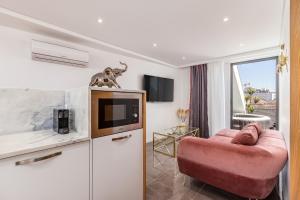 ein Wohnzimmer mit einem rosa Sofa und einem Fernseher in der Unterkunft Nell&And&Jess in Espinho