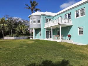 una casa blu con un prato davanti di AIRBAB Moon Gate East a Mount Pleasant