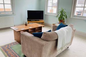 a living room with two chairs and a table with a television at 2 Bedroom Flat in the Heart of Berkeley in Berkeley
