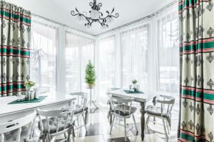 - une salle à manger avec une table, des chaises et des fenêtres dans l'établissement Willa Biały Domek, à Zakopane