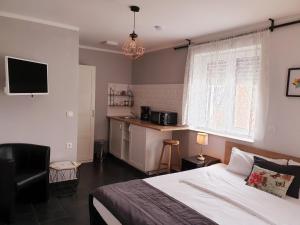 a bedroom with a large bed and a kitchen at Oleander Hof in Hochstadt