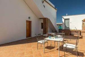 patio z krzesłami i stołem w budynku w obiekcie Apartamento Bolonia Luz B w mieście Bolonia