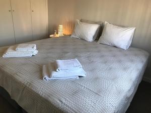 a bed with white towels on top of it at Casas da Praia in Manta Rota