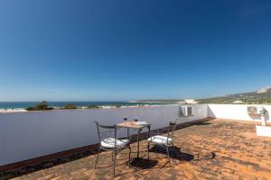 a table and chairs on a patio with a view of the ocean at Apartamento Bolonia Luz B in Bolonia