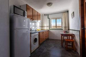 a kitchen with a refrigerator and a washing machine at Apartamento Bolonia Luz B in Bolonia