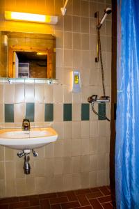 a bathroom with a sink and a mirror and a shower at Tysfjord Hotel in Storjord I Tysfjord