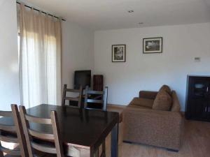 - un salon avec une table et un canapé dans l'établissement Apartamentos Puerta de Ordesa, à Laspuña