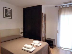 a bedroom with a bed with three towels on it at Apartamentos Puerta de Ordesa in Laspuña
